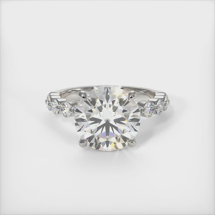 This gorgeous Round Moissanite and Lab-Created Diamonds Engagement Ring is sure to thrill her! This lovely sparkling ring in gold or platinum features a Colorless Round Moissanite set into the elegant 4 prong tulip pave head. This bridal ring is available in 2ct, 3ct, 4ct/ AGI Design