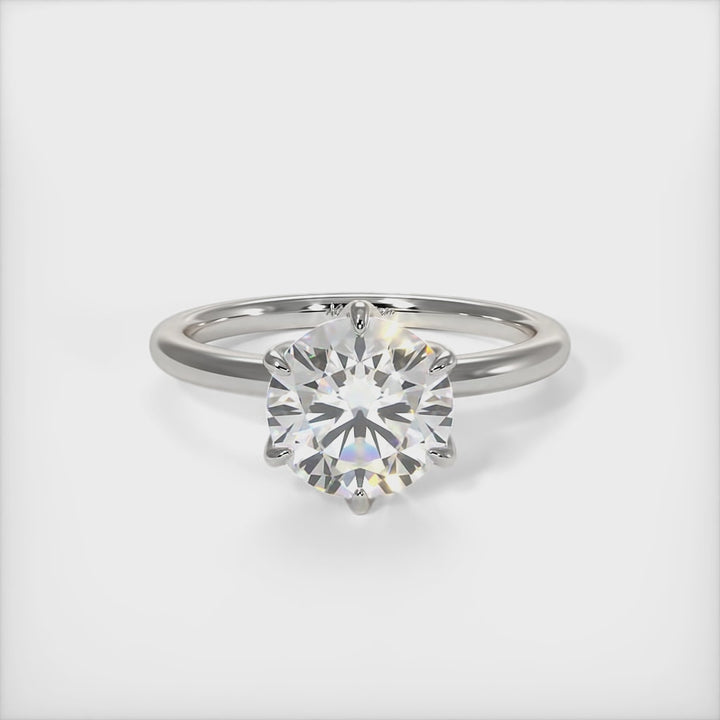 A beautiful engagement ring in gold or platinum that includes a 1ct, 2ct, 3ct round Colorless Moissanite set into the 6 prongs setting. This solitaire ring is designed to allow the wedding band to sit close and flush with the engagement ring because the center stone sits directly above the band./AGI Design