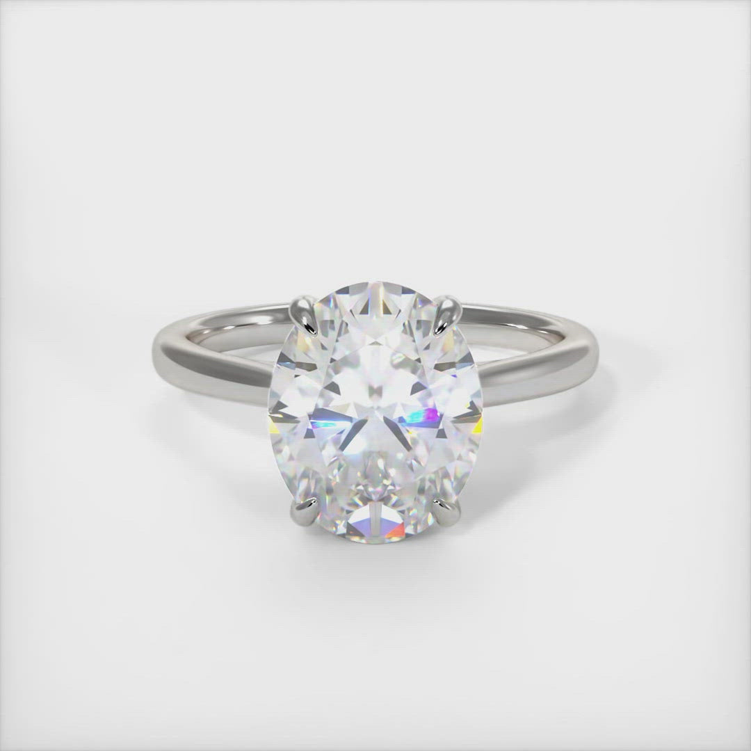 Bella oval moissanite engagement ring. Crafted in solid gold or platinum, this intriguing design features a sparkling oval-shaped moissanite center stone wrapped in a lab-created diamond-adorned hidden hallo frame. Sizes 1ct, 2ct, and 3ct are available for this unique solitaire ring /AGI Design