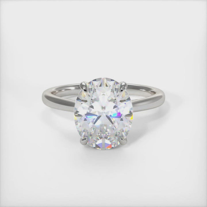 Bella oval moissanite engagement ring. Crafted in solid gold or platinum, this intriguing design features a sparkling oval-shaped moissanite center stone wrapped in a lab-created diamond-adorned hidden hallo frame. Sizes 1ct, 2ct, and 3ct are available for this unique solitaire ring /AGI Design