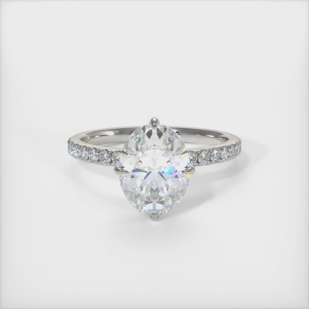 Patricia Oval Moissanite Engagement Ring - AGI Design/An engagement ring that includes an oval Colorless Moissanite set into the 4 prongs compass setting. Each claw points to North, East, South, West in contrast to the traditional "box" style arrangement when the diamond is set to square on. The 2ct delicate bridal band is covered with high-quality Lab-created diamonds.