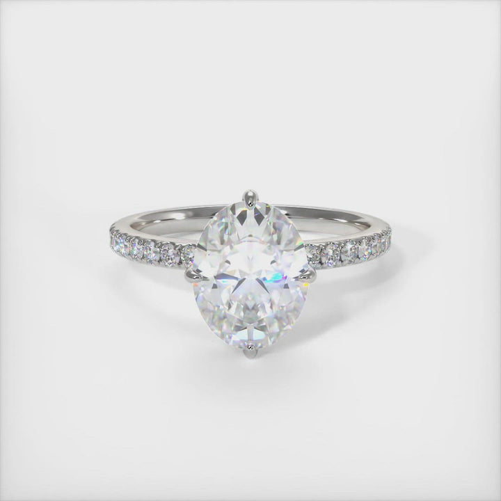 Patricia Oval Moissanite Engagement Ring - AGI Design/An engagement ring that includes an oval Colorless Moissanite set into the 4 prongs compass setting. Each claw points to North, East, South, West in contrast to the traditional "box" style arrangement when the diamond is set to square on. The 2ct delicate bridal band is covered with high-quality Lab-created diamonds.