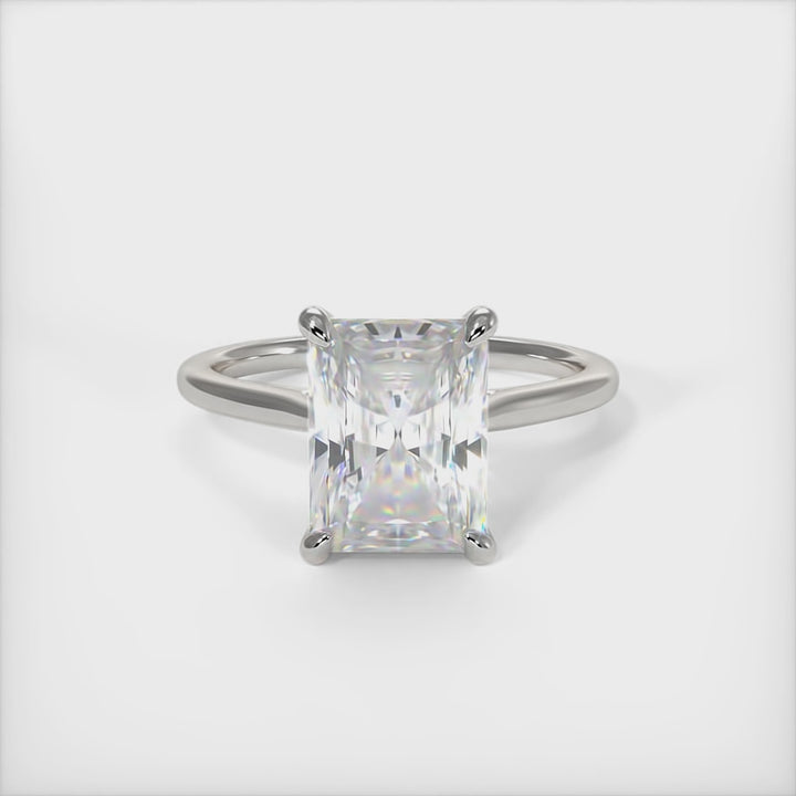 A beautiful Engagement ring in gold or platinum that includes a 1ct, 2ct Radiant Moissanite set into the 4 prongs hidden halo setting. The band and the halo are covered with Lab-created diamonds. This  solitaire ring is designed to allow the wedding band to sit close and flush with the engagement ring because the center stone sits directly above the band. AGI Design