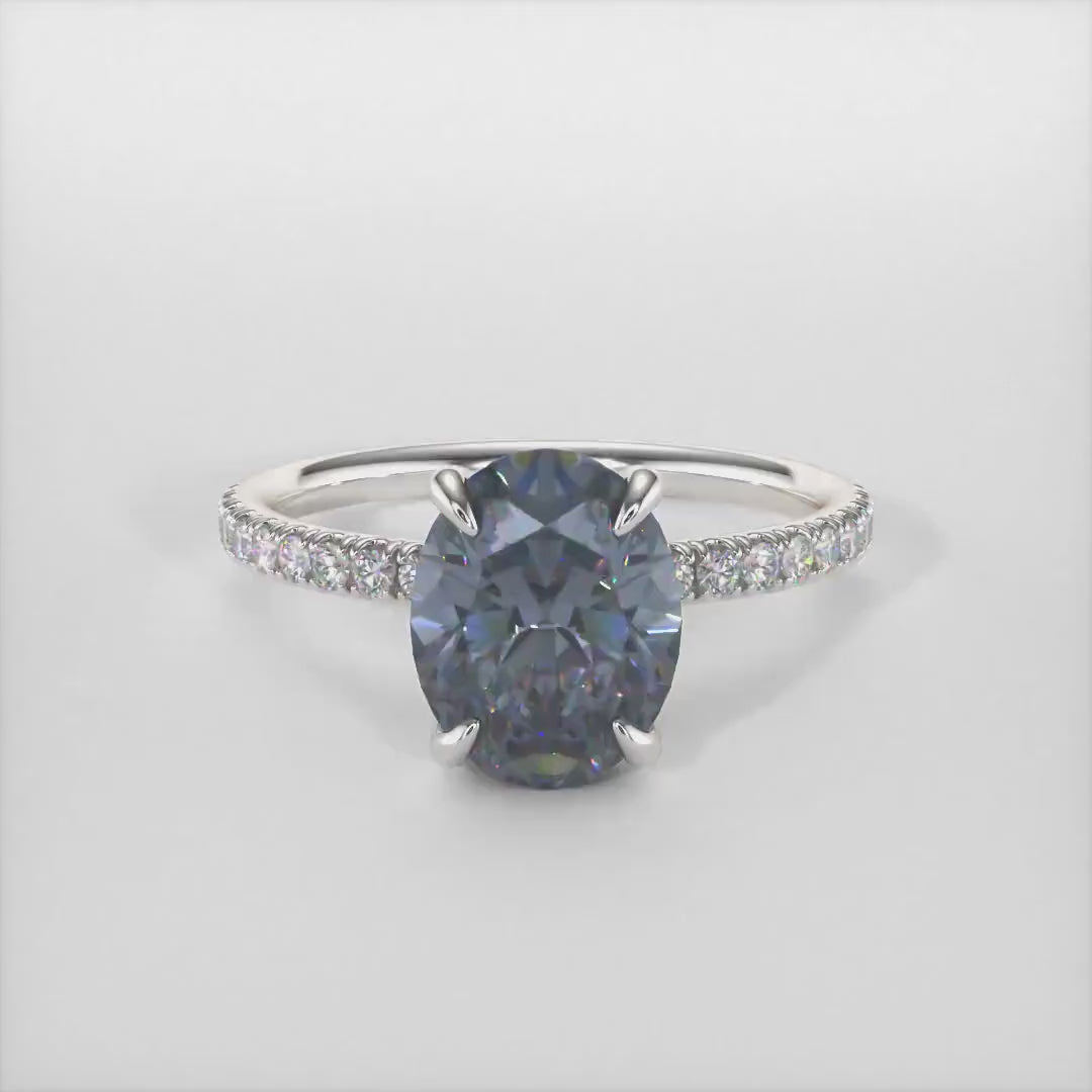 Abigail Oval Dark Gray Moissanite Engagement Ring/ AGI Design. A beautiful engagement ring in gold or platinum that includes a gray Oval Moissanite set into the 4 prongs hidden halo setting. The band and the halo are covered with lab-created diamonds. This solitaire ring is designed to allow the wedding band to sit  flush with the engagement ring because the center stone sits directly above the band.