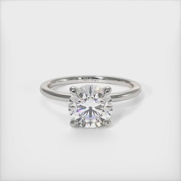 A beautiful engagement ring in gold or platinum that includes a  1ct,  2ct, 3ct round Colorless Moissanite set into the 4 prongs setting. This solitaire ring is designed to allow the wedding band to sit close and flush with the engagement ring because the center stone sits directly above the band./ AGI Design