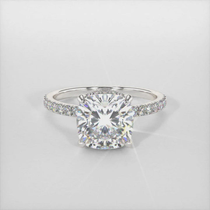 This beautiful Engagement Ring is made of solid 14K and 18K, or Platinum, and includes a Colorless  Cushion Cut Moissanite and lab-created diamonds on the band and the hidden halo. With a collar under the stone and diamonds on the shank, this ring is just gorgeous! AGI Design