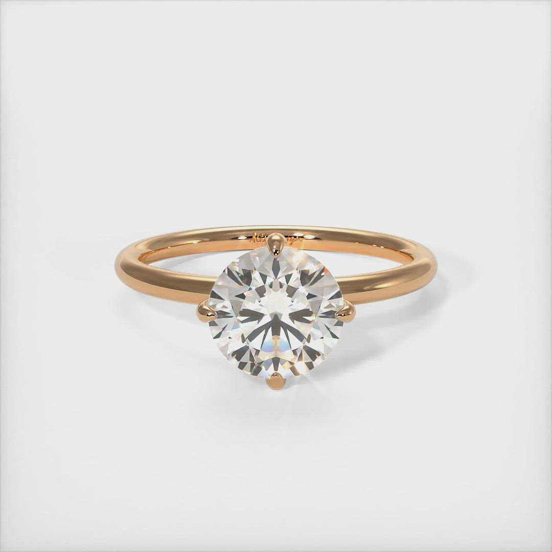 Lisa Round Moissanite Engagement Ring - AGI Design/A beautiful Engagement ring in gold or platinum that includes a round colorless Moissanite set into the 4 prongs compass setting. Each claw points to North, East, South, West in contrast to the traditional "box" style arrangement when the moissanite is set to square on. 1ct, 2ct, 3ct solitaire rings are available.