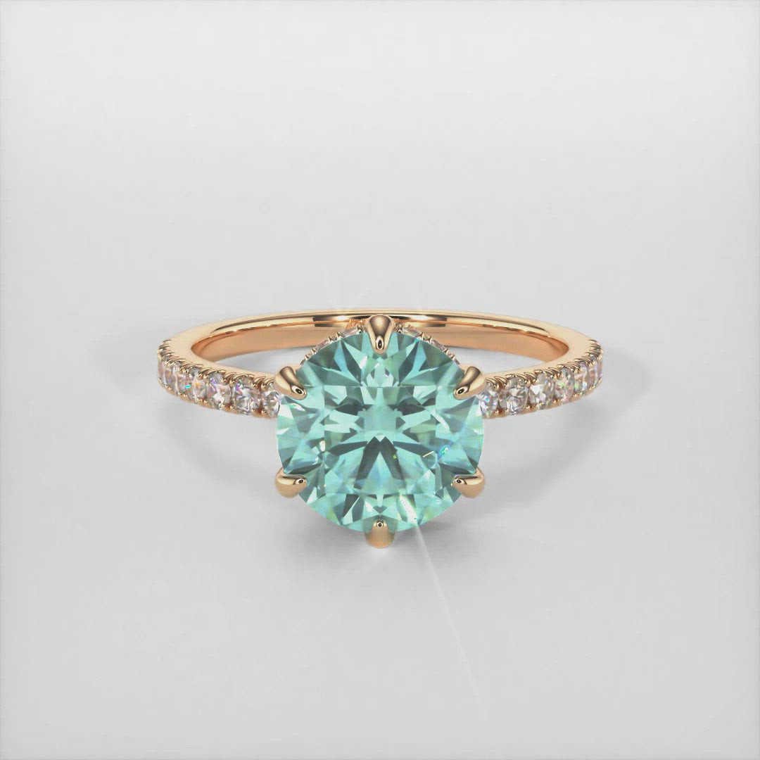 Jenny round aqua teal moissanite engagement ring/AGI Design/This incredible engagement ring in gold or platinum features a round Aqua Teal Moissanite in a 6 prong setting surrounded by a hidden halo of round lab-created brilliant diamonds that make their way down the ring’s shank. This 1ct, 2ct ring is designed to allow the wedding band to sit close and flush with the engagement ring.