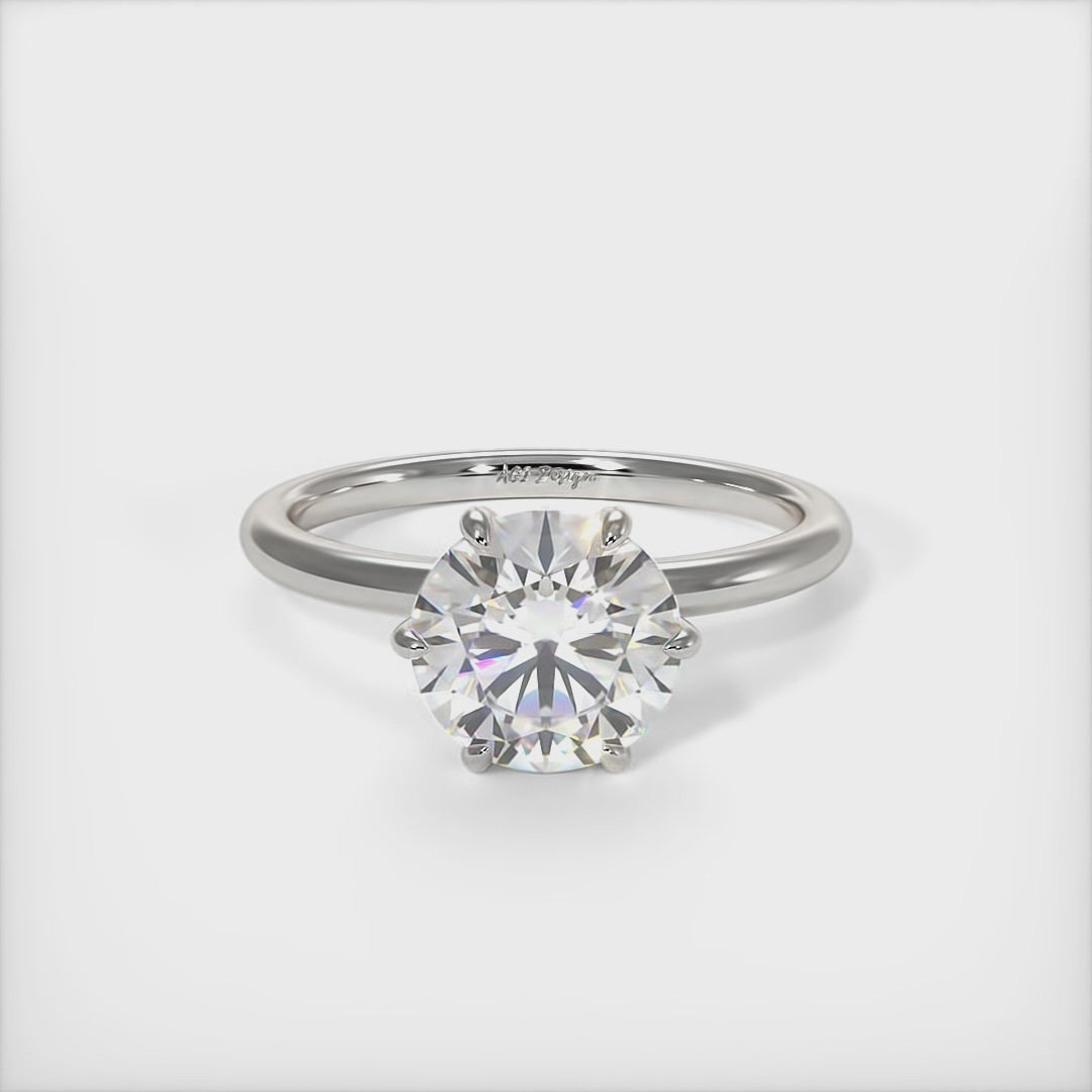 A beautiful engagement ring in gold or platinum that includes a  1ct,  2ct, 3ct round Colorless Moissanite set into the 4 prongs setting. This solitaire ring is designed to allow the wedding band to sit close and flush with the engagement ring because the center stone sits directly above the band./AGI Design