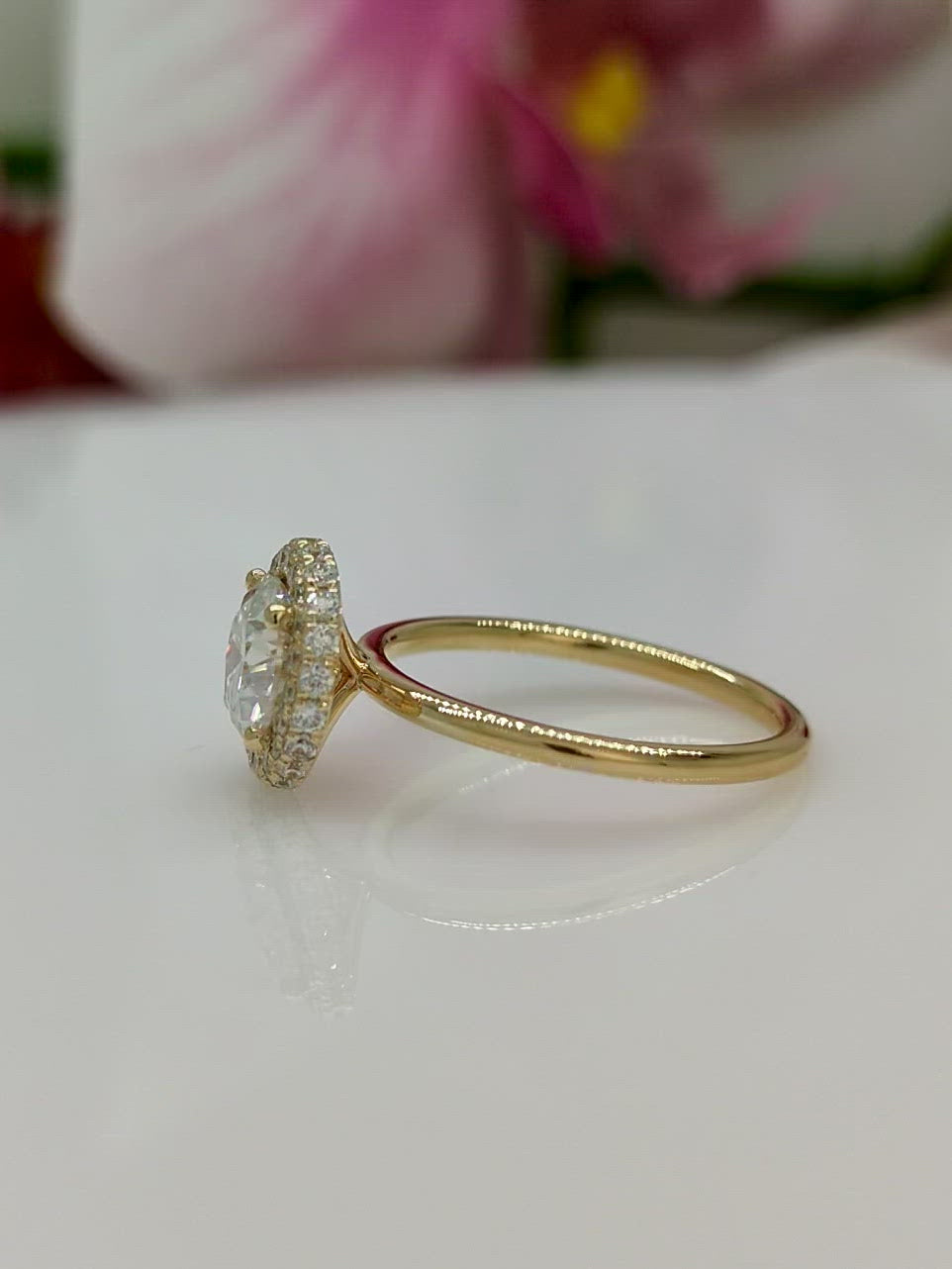 The delicate Hidden Halo Round Colorless Moissanite Engagement Ring. The gold or platinum band and the halo are covered with high-quality lab-created diamonds. This 1ct, 2ct, 3ct solitaire ring is designed to allow the wedding band to sit flush with the engagement ring because the center stone sits directly above the band. /AGI Design