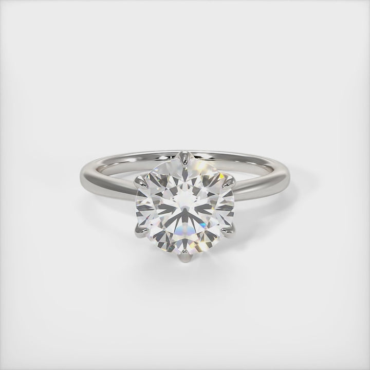 A beautiful engagement ring in gold or platinum that includes a  1ct,  2ct, 3ct round Colorless Moissanite set into the 6 prongs setting. This solitaire ring is designed to allow the wedding band to sit close and flush with the engagement ring because the center stone sits directly above the band./AGI Design